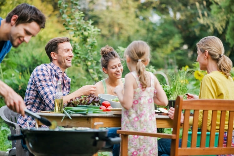 Famille autour d'un barbecue dans le jardin