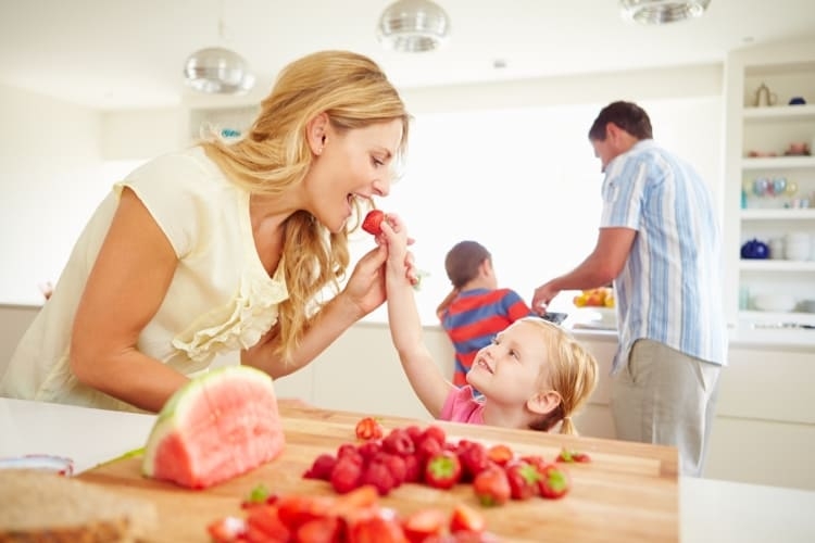 Mère et enfant grignotant des fraises fraîches