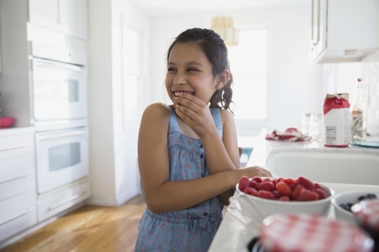 enfant heureux grignote des framboises fraîches