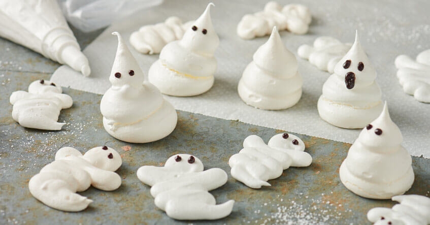 meringues en forme de fantômes sur du papier cuisson